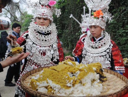 台江县老屯乡老屯村的苗族姑娘在寨门前用“姊妹饭”迎接客人。